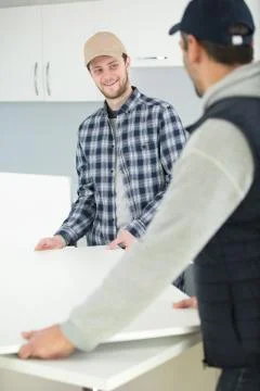 Two men having fun when furnishing new house Stock Photos