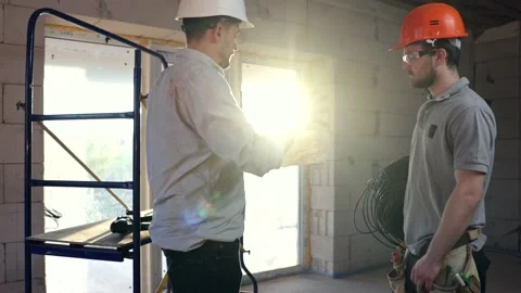 Two men in helmets discuss a project on securities. Stock Footage 156307973