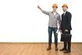 The two men in helmets gesture on the white wall background Photo