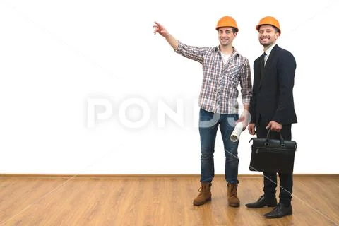 The two men in helmets gesture on the white wall background Stock Photos