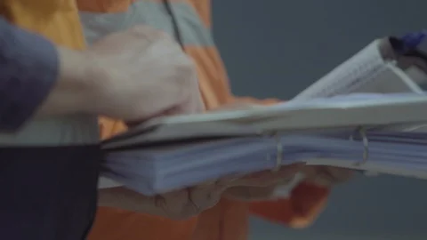 Two men in high visibility work gear take notes Video stock 86263070