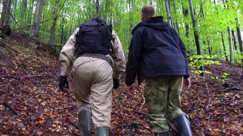 Two men hiking through muddy trail in the forest. Video stock 78626077