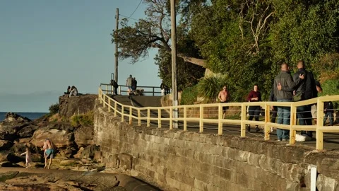 Two men hold each other on busy coastal path in Sydneys Manly slow motion Stock-Footage 292245899