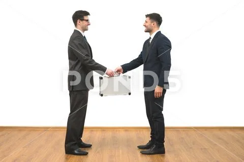 The two men hold a metal case on the white wall background Stock Photos