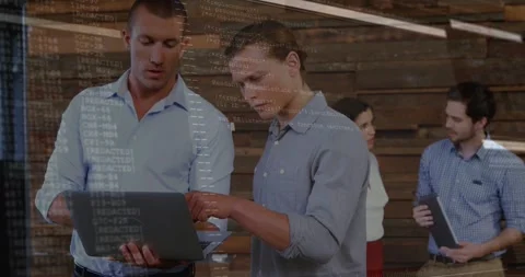 Two men holding laptop and pointing screen, creating code overlay while dev team Stock Footage 334039081