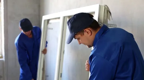 Two men inspect new window frame before installing it to place. Stock Footage 50282434