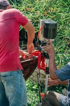 Two Men Installing Outboard Motor on Wooden Boat Stock Photos