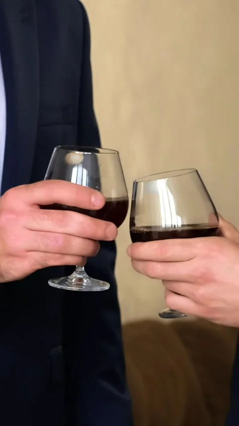 Two men in a jacket and shirt clink glasses with whiskey close-up. Slow motio Stock Footage 291955237
