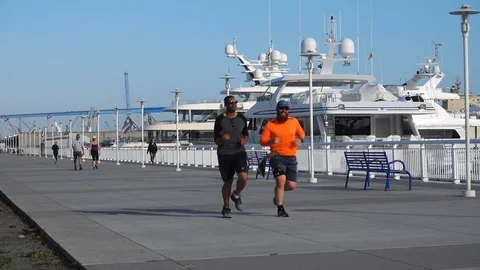 Two men jogging along the San Diego Marina Stock Footage 109180276