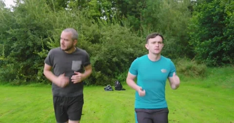 Two men jogging in park, enjoying outdoor exercise and fresh air Stock Footage 346295974