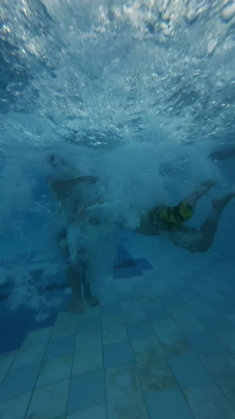 Two Men Jumping Into Swimming Pool with Underwater Splash, Slow Motion Vertical Stock Footage 338314940