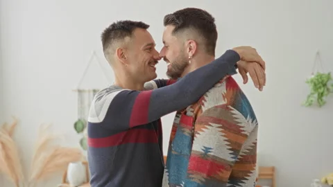 Two men kissing, lips joined and arms around shoulders in a bright living r.. Stock Footage 339217244