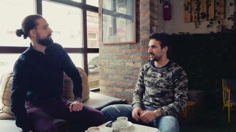Two men laughing and talking in a cafe 스톡 동영상 95904981