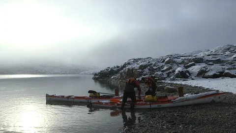 Two men leaving an Arctic beach in kayak, Greenland Video stock 104181021