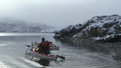 Two men leaving an Arctic beach in kayak, Greenland Stock-Footage 104181050