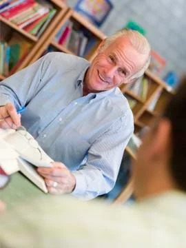 Two men in library with notepads talking (selective focus) Stock Photos