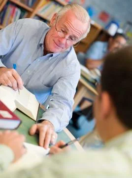 Two men in library with notepads talking (selective focus) Stock Photos