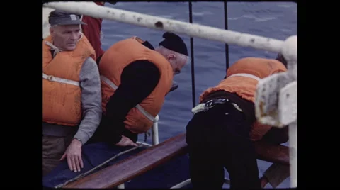 Two Men in Life Vests Look Down to Water Stock Footage 47646578