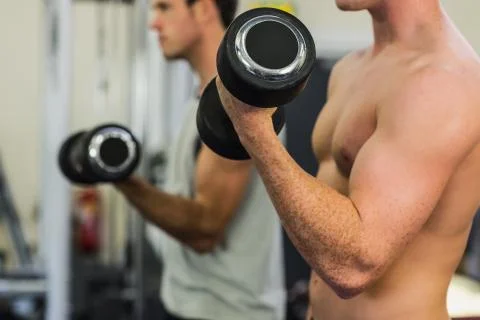 Two men lifting dumbbells Photos