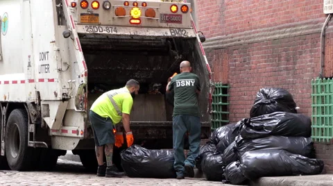 Two men loading trash into garbage truck in New York 4k Stock Footage 68207259