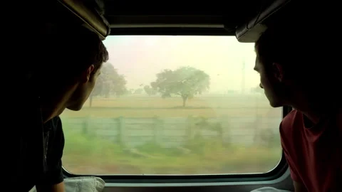 Two Men Looking Out Train Window in India, Friends Traveling on Indian 스톡 동영상 329749591