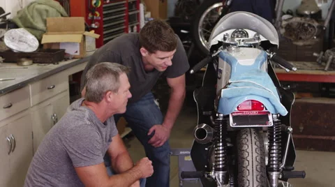 Two men looking over motorcycle Stock-Footage 67345825