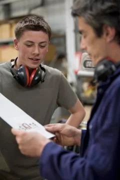 Two men looking at the quality of print samples Stock Photos