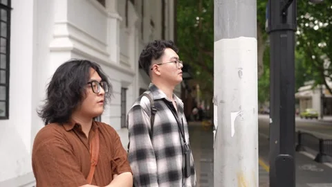 Two men looking upward beside city wall Stock Footage 346302719