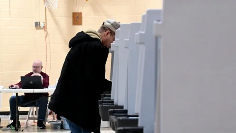 Two men mark their primary ballots at voting booths. Stock-Footage 126129626