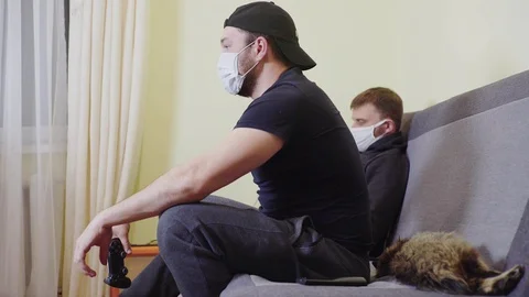 Two men in masks during the epidemic of coronavirus rest laugh and fun, playing Stock Footage 128765971