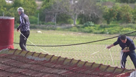 Two Men Measuring Distances on a House Roof Vídeos de archivo 327715587