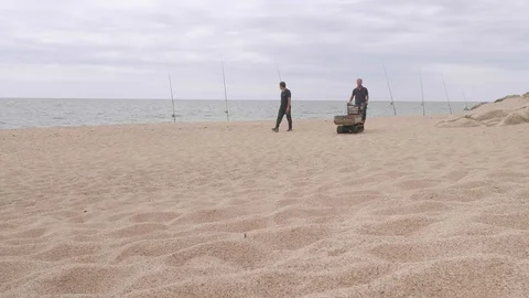 Two men with mechanized trolley on beach taking away garbage. Stock Footage 115771736