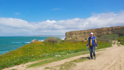 Two Men Meet on a Path near the Ocean Stock Footage 90093895