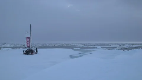 Two men moving a catamaran on the ice floe, North Pole Stock Footage 104924369