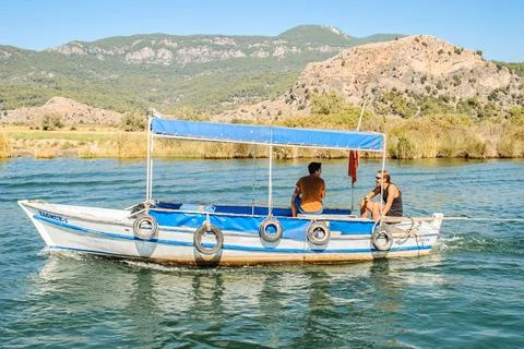 Two men navigate a river using a motorboat with a canopy Foto stock