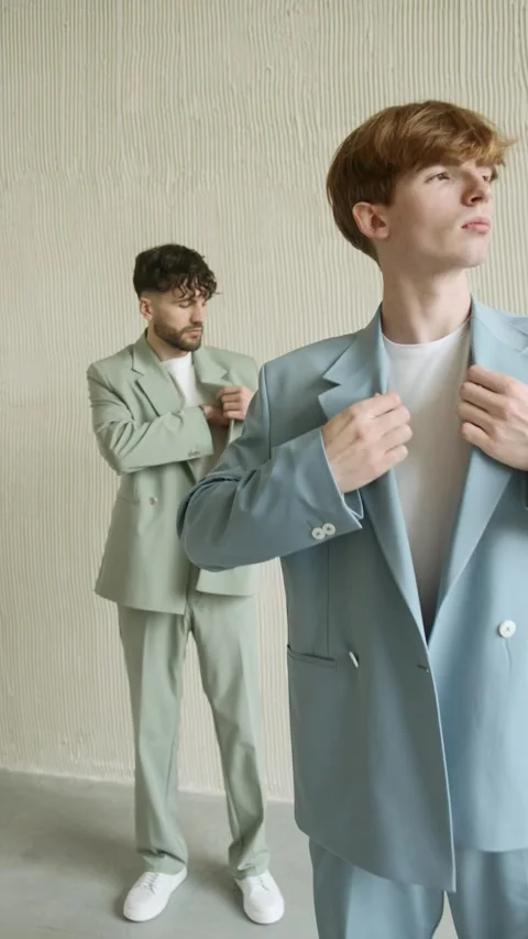 Two men in new suits standing in front of wall Stock Footage 274163802