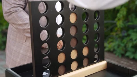 Two men in office clothes are playing wooden game of four in a row outdoor. Stock Footage 246542824