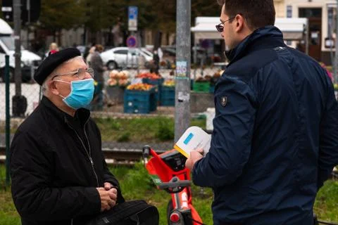 Two men (one with mask) are talking at Hradcanska metro station in Prague. Stock Photos