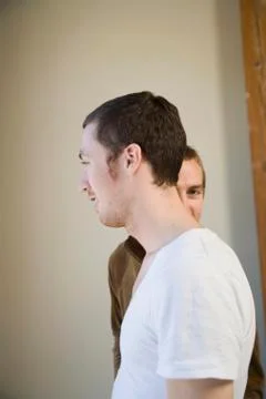 Two men, one standing in front of the other Stock Photos