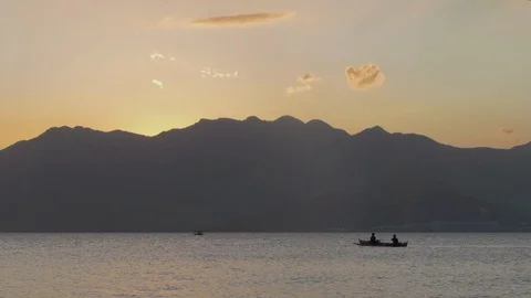 Two men paddling a boat with mountain an... | Stock Video | Pond5