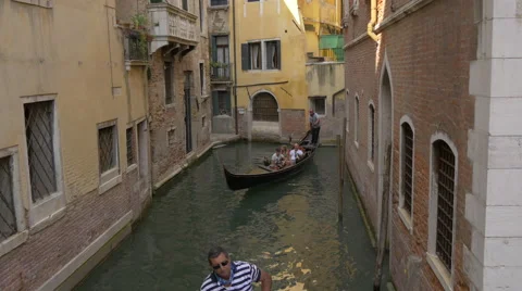 Two men paddling gondolas in a beautiful canal in Venice Stock Footage 58805486