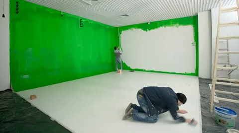 The two men paint the wall and floor in the green. Time lapse. Wide angle Stock Footage 61438938