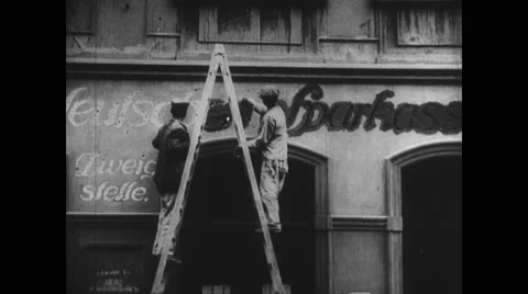 Two men painting signboard of a shop Stock Footage