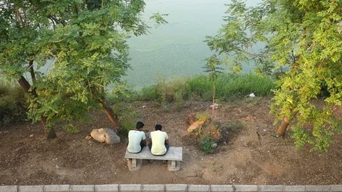 Two men on park bench in India Stock Footage 87815161