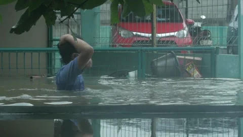 Two men passed in the middle of a deep flood. Stockbeeldmateriaal 149550456