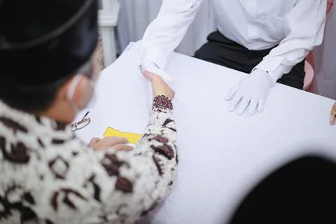 Two men perform a ceremonial handshake during a formal traditional event. Stock Photos