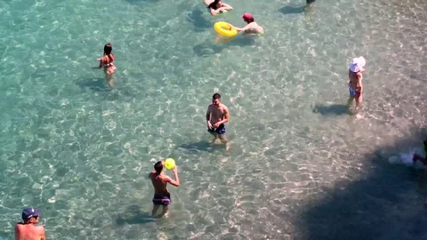 Two men play with a ball in blue ocean water Stock Footage 79752787