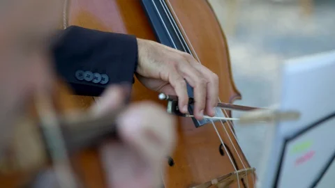 Two men play the cello and violin on a summer day. Close-up Stock Footage 128428207
