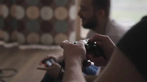 Two men play in game, holding game consoles in room indoors. Stock Footage 83027793