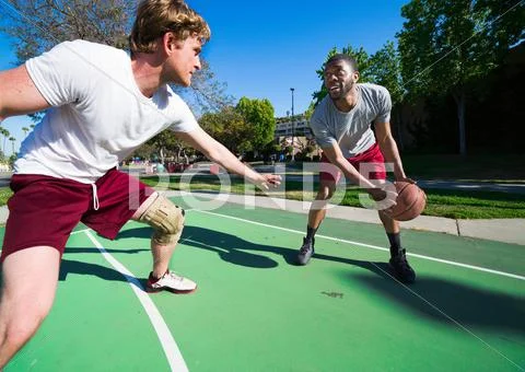 Two Men Playing Basketball On Outdoor Court